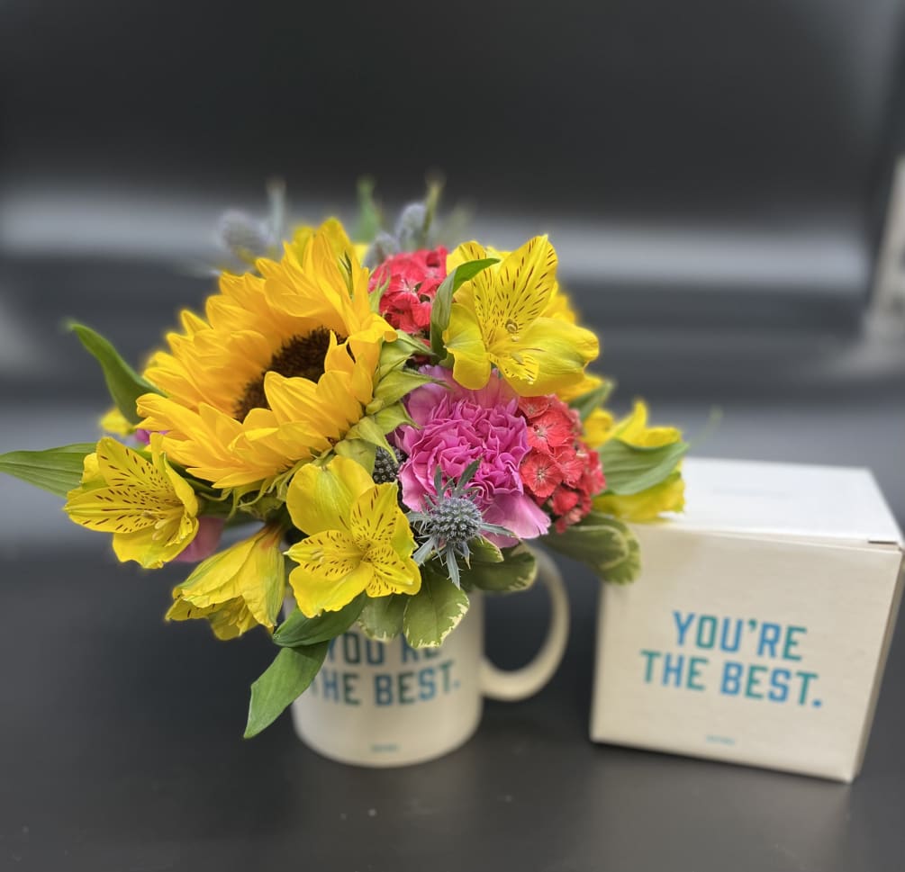 Bright seasonal flowers will be arranged in our 14oz ceramic mug .