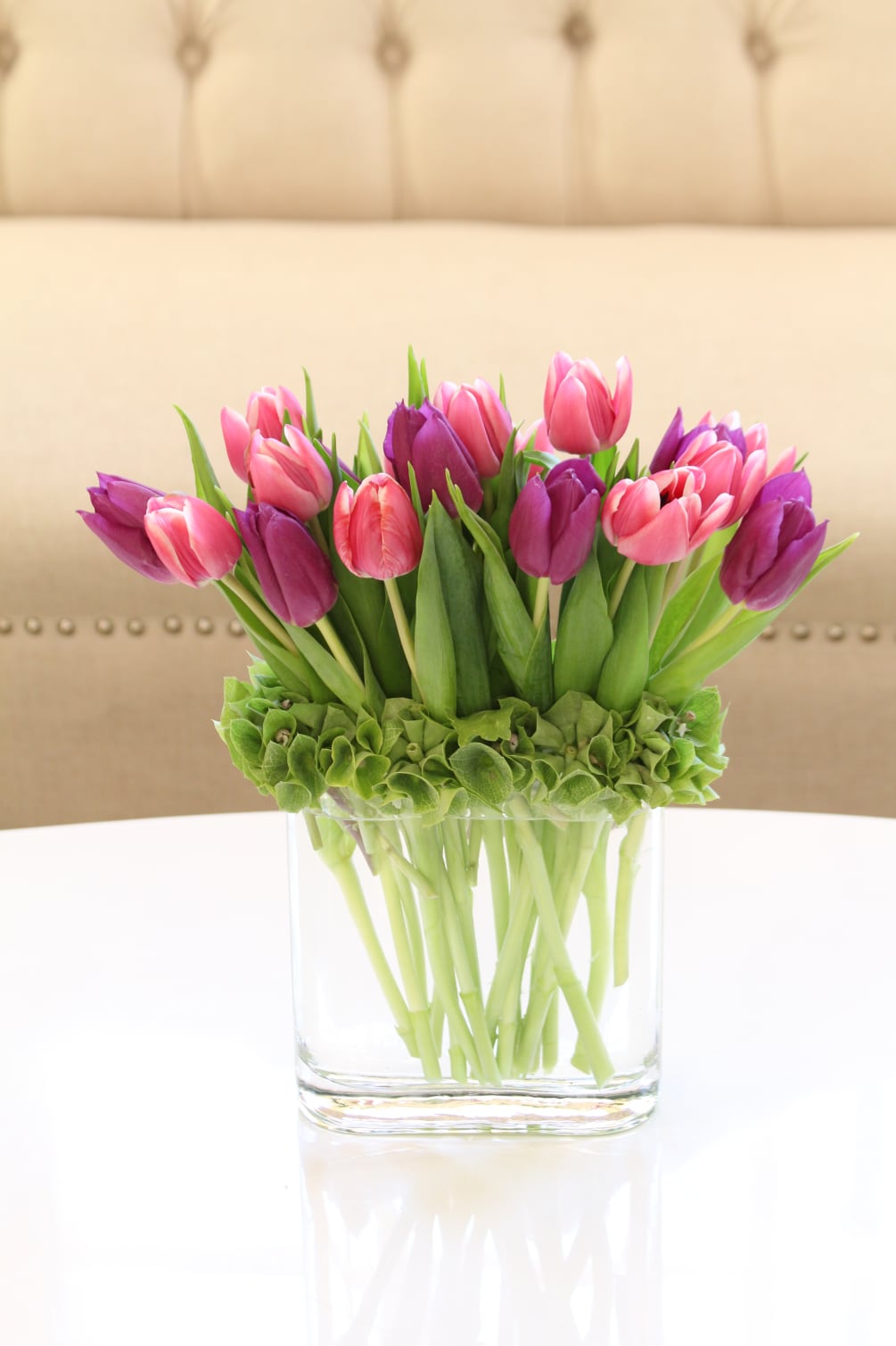 Modern style arrangement of assorted colored tulips accented with bells of Ireland.

Vase