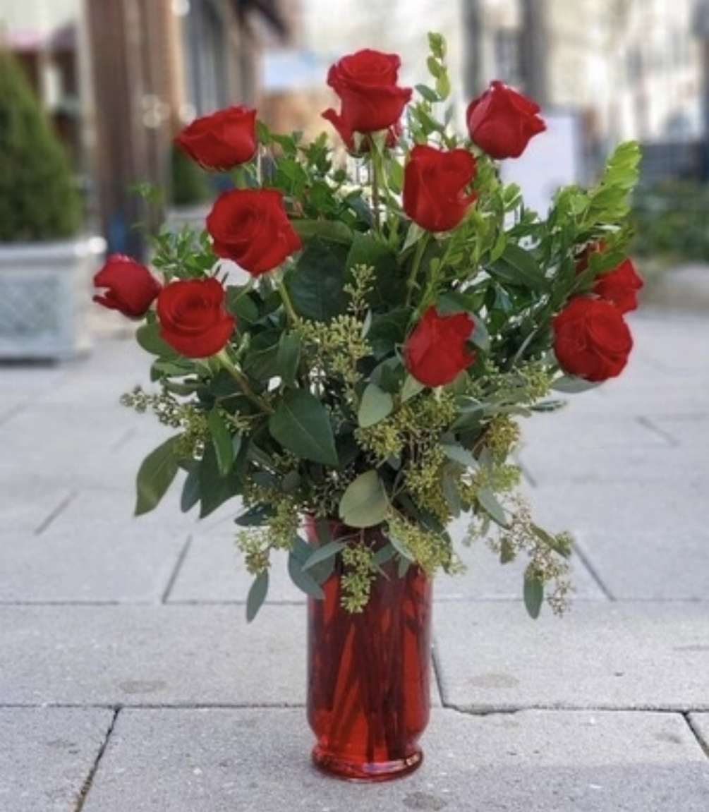 One dozen long stem red roses in a red vase