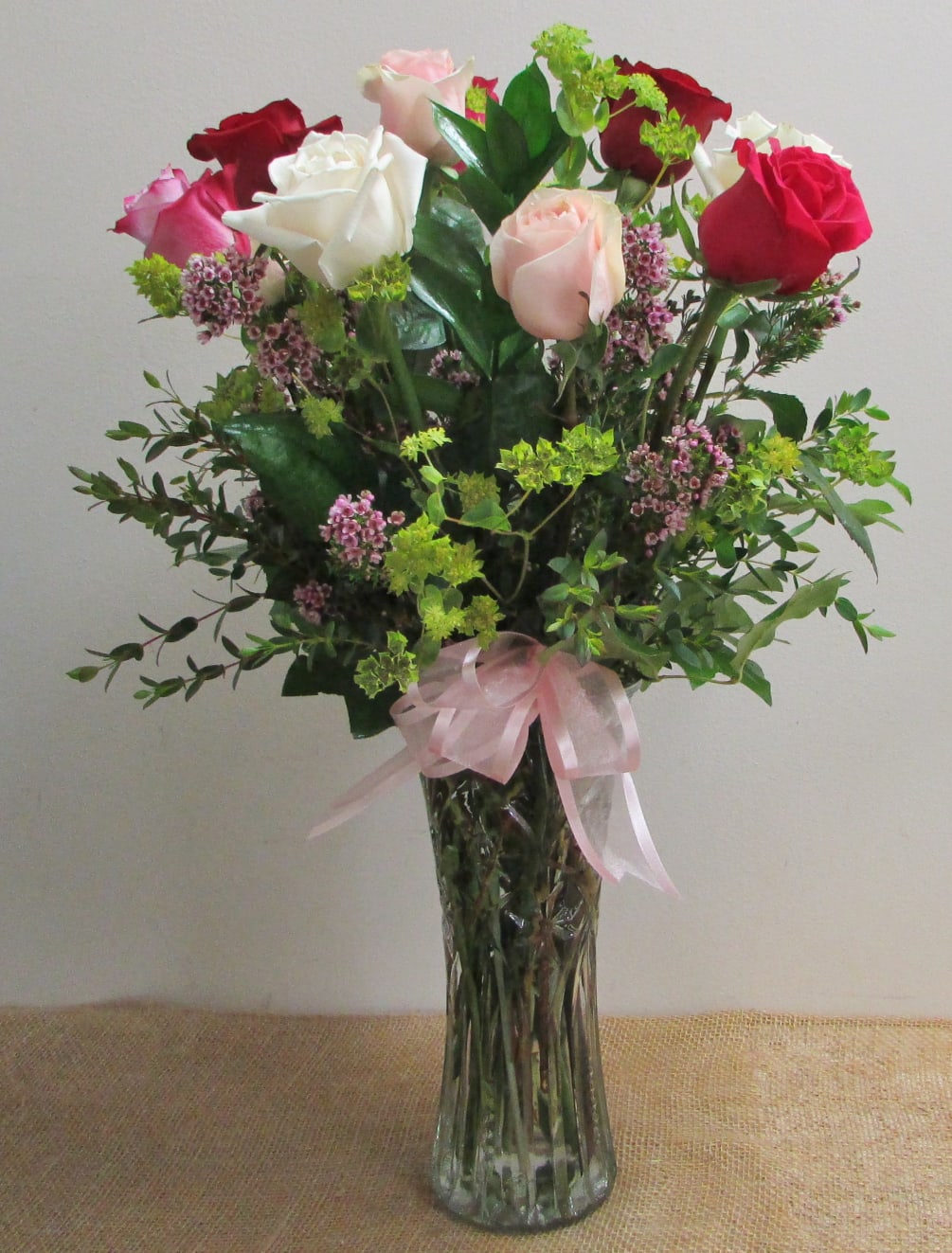 A beautiful arrangement of one dozen assorted color roses. The pops of