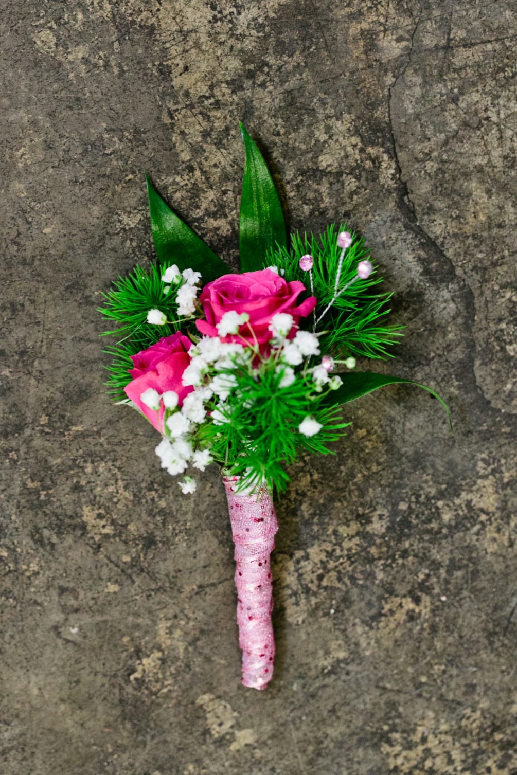 Select this bright bold pink boutonniere of spray roses, babies breath and