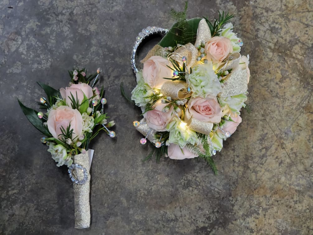 A wrist corsage and boutonniere set with light pink spray roses, white