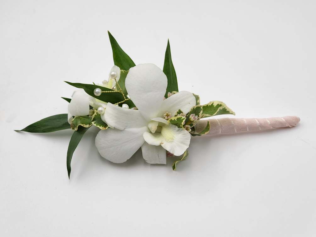 A boutonniere of white dendrobium orchids, light pink ribbon, pearl sprays.

Depending on