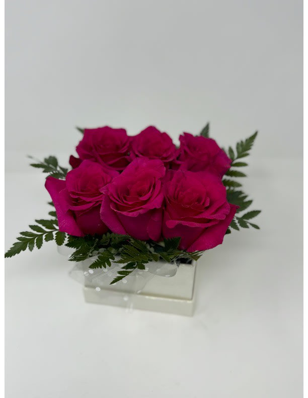 A half dozen of exquisite roses elegantly nestled in a sparkling iridescent