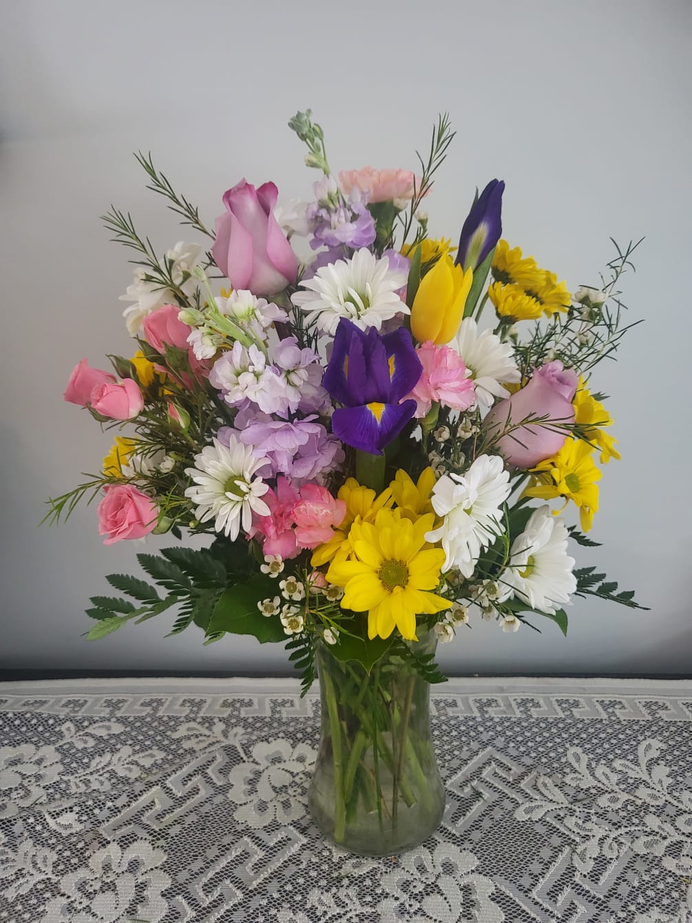 Summer colors and blooms like iris ,roses,daisies and mini pink carnations