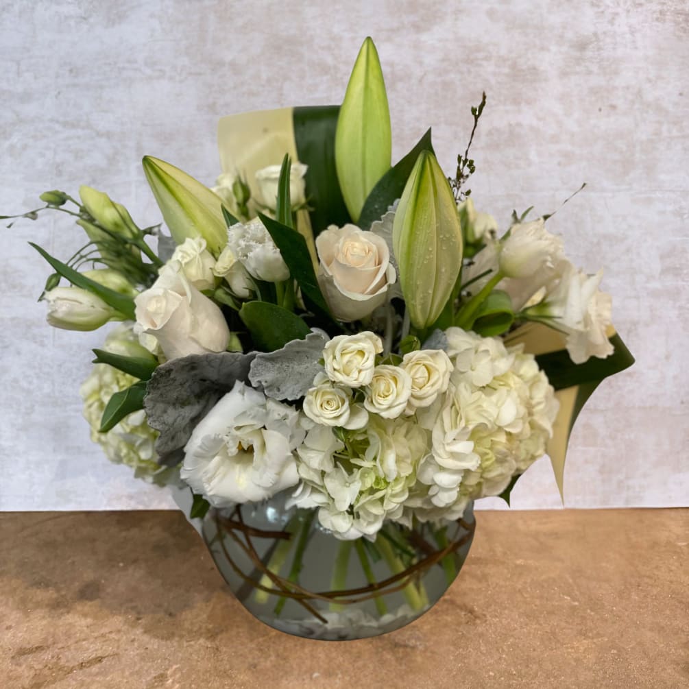 A tranquil blend of white roses, hydrangeas, and lilies, elegantly accented with