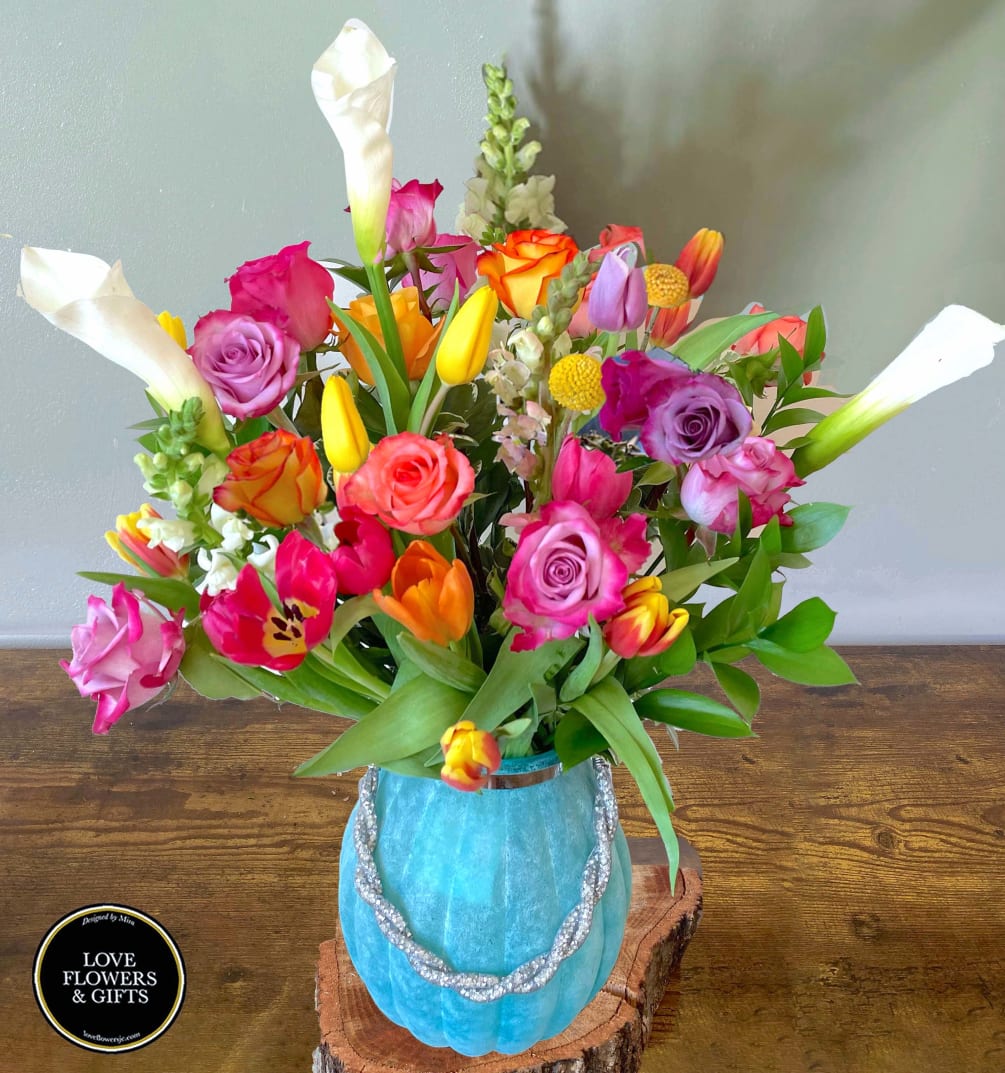 Awaken Spring with this beautiful arrangement designed in a blue frosted vase