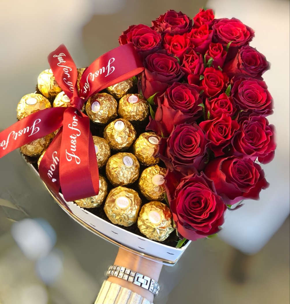 Beautiful red roses mix with chocolates in a heart shape. 