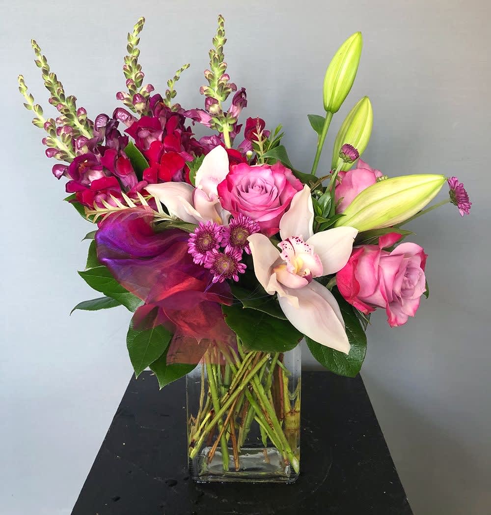 Different tipes of beautiful flowers, roses, lilies,snapdragon,orchid in a beautiful glass vase.