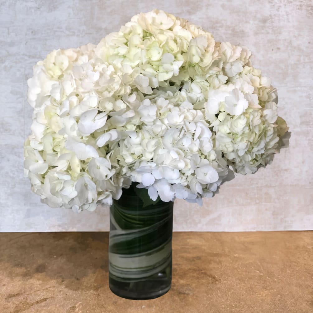 This arrangement showcases timeless elegance with its lush, voluminous clusters of pristine