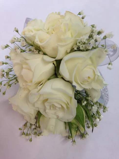 white spray roses with seasonal garnish wrapped with sheer ribbon.
can be different