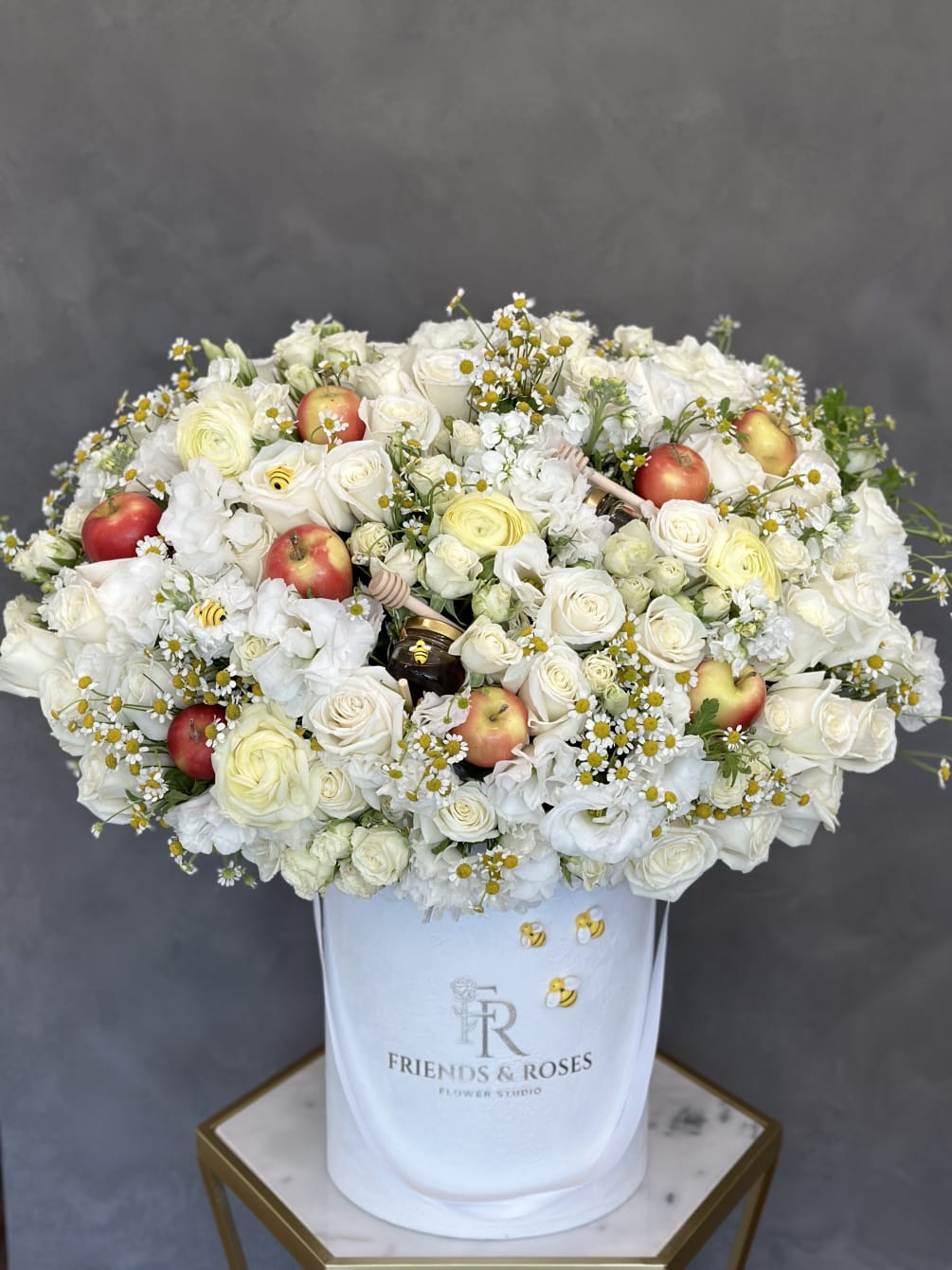 Festive arrangement of white flowers, fresh apples, and honey in our signature