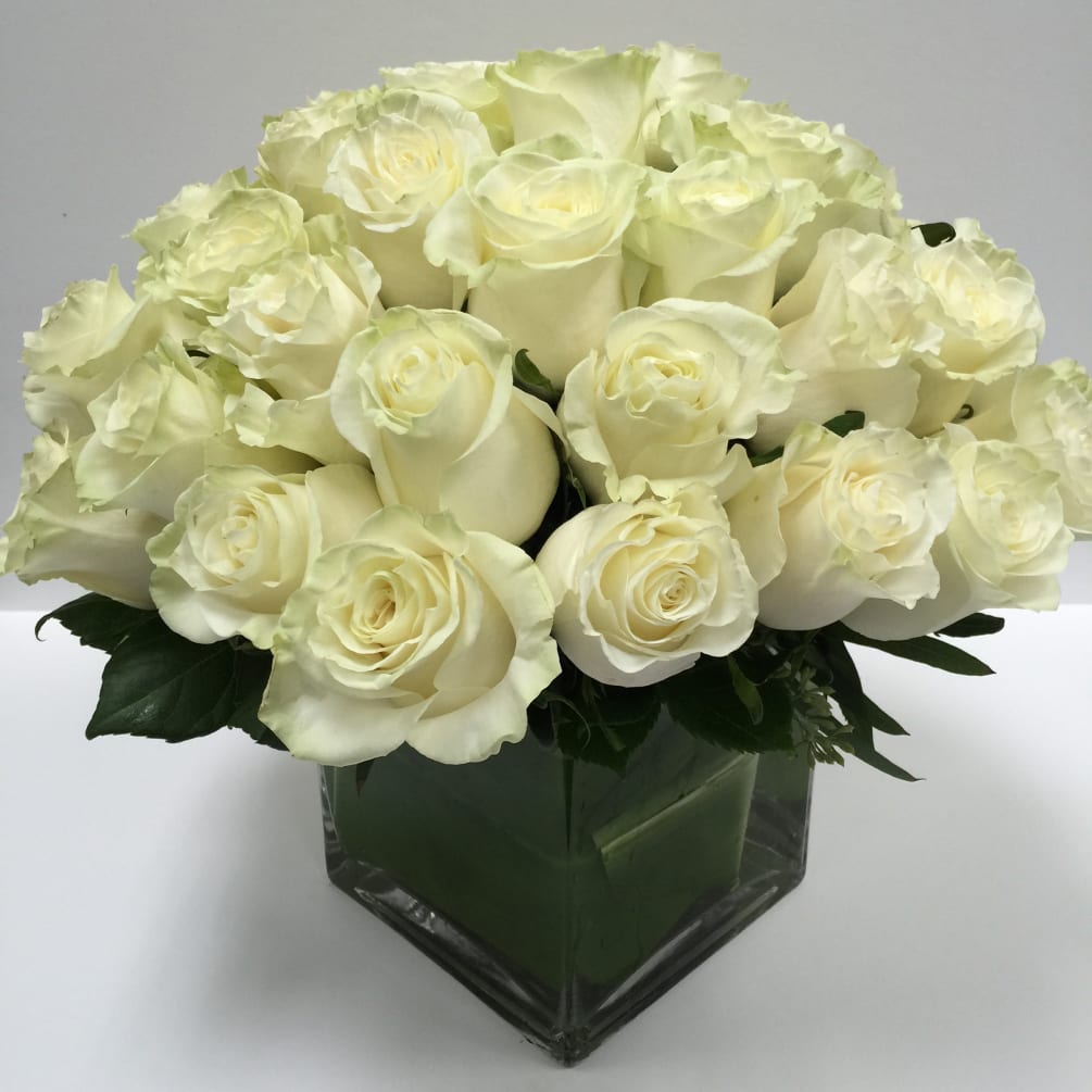 A gorgeous pave of all white roses clustered in a glass square.