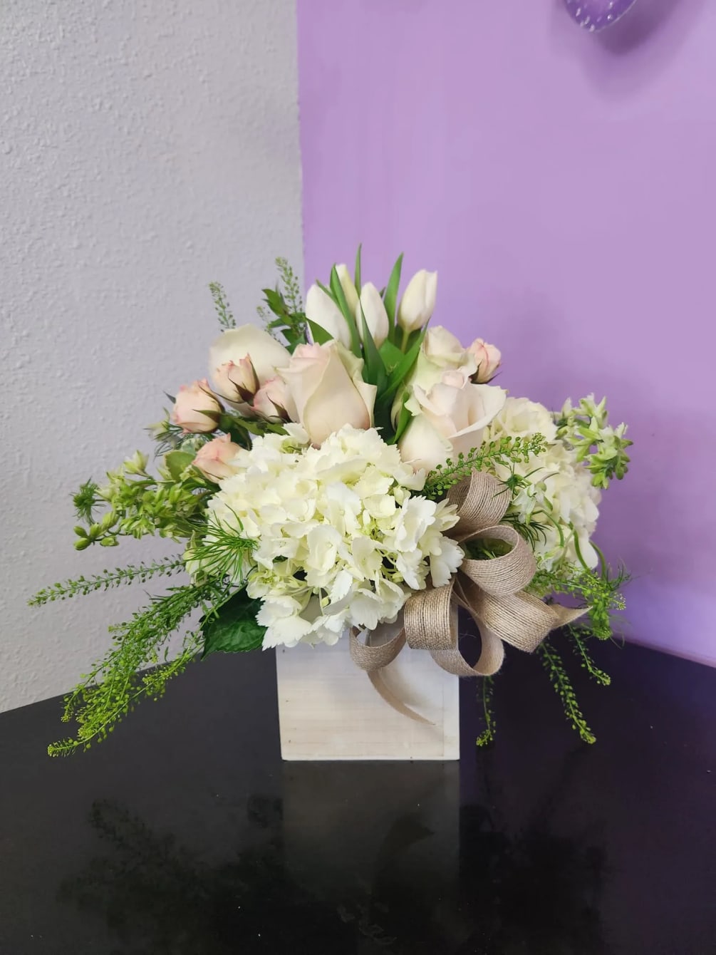 This sophisticated arrangement features an elegant mix of white and cream blooms