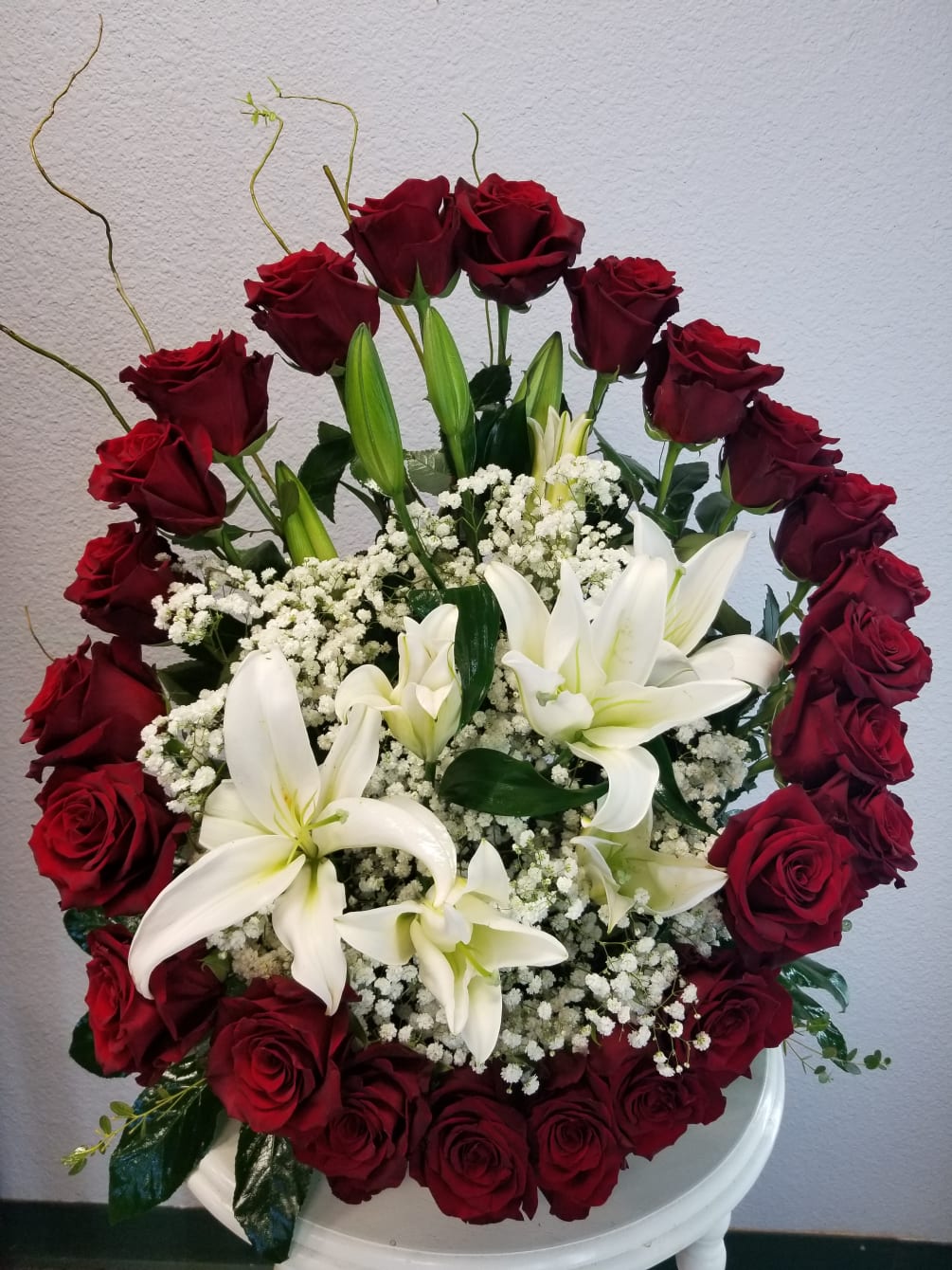 Two dozen red roses accented with White Lilies. 
**Local delivery or pick