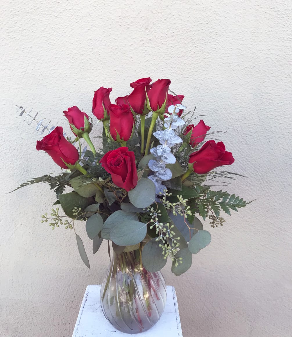 Our premium longstem imported red roses beautifully arranged with various greens in