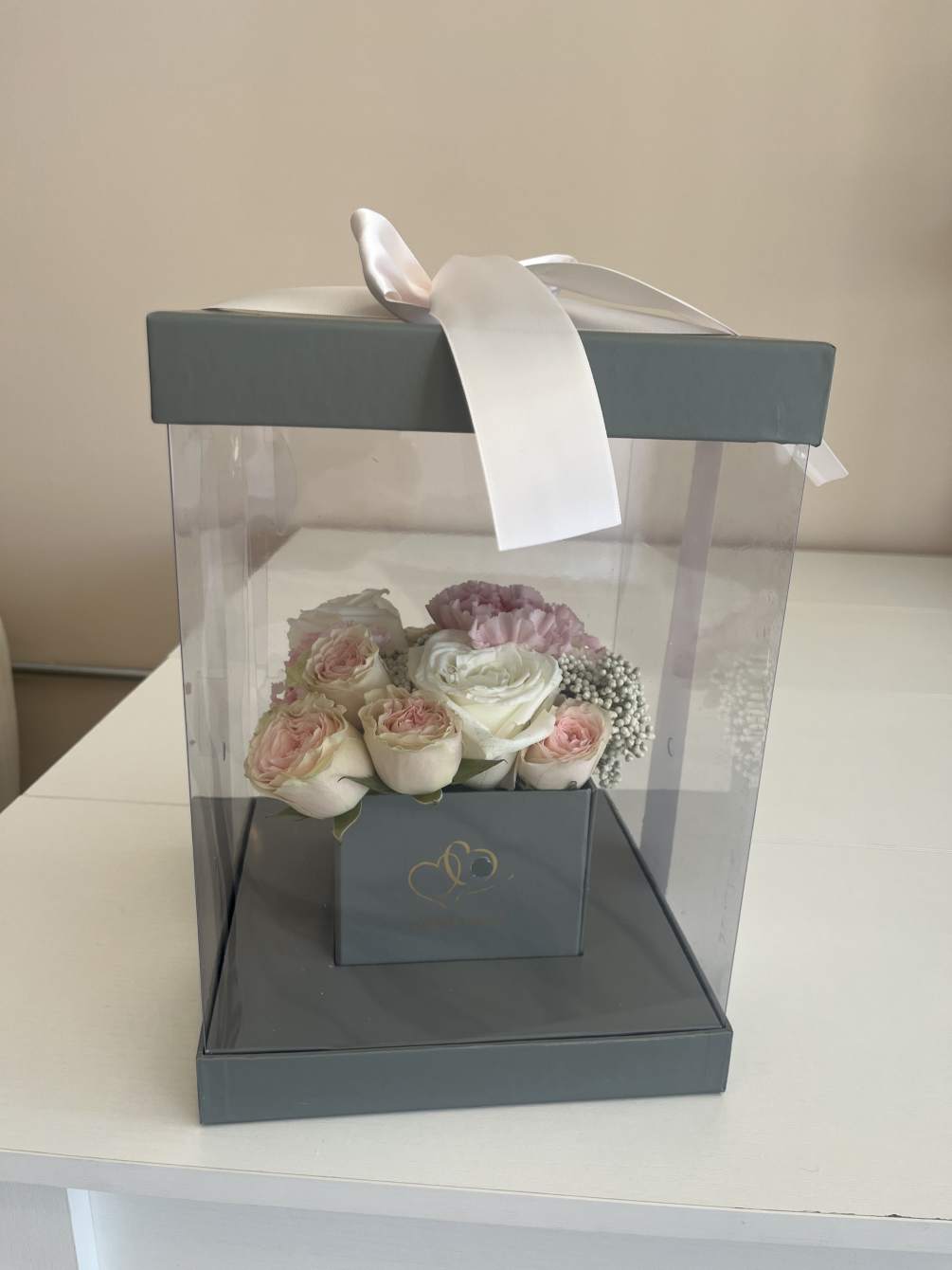 Clear square box, center mixed flowers 

**Please note picture is example of