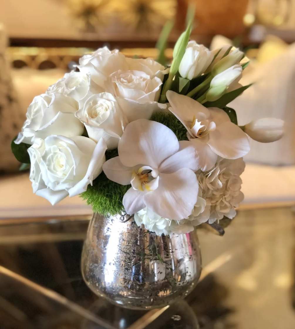 Beautiful arrangement of white Blooms in silver vase 
