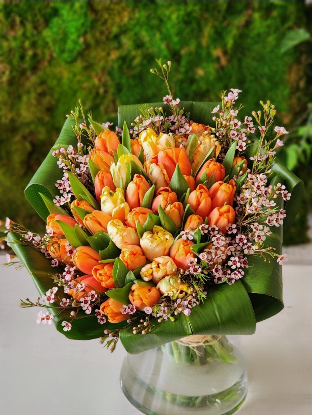 Bright orange and peach tulips in a clear vase look absolutely stunning