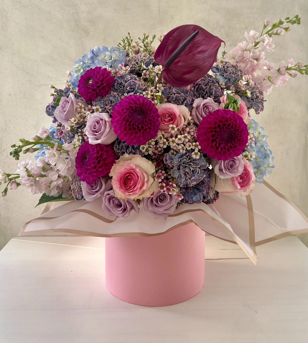 This arrangement captivates with its rich shades of purple. Each flower, was