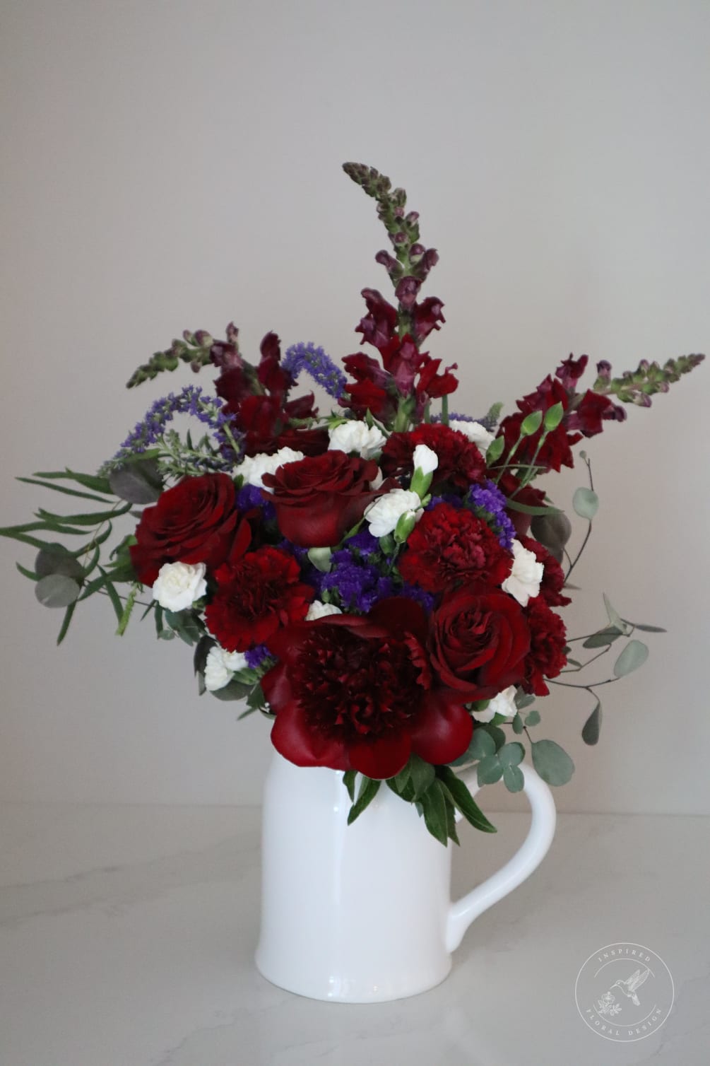 This elegant and regal floral arrangement is incredibly beautiful with deep colors