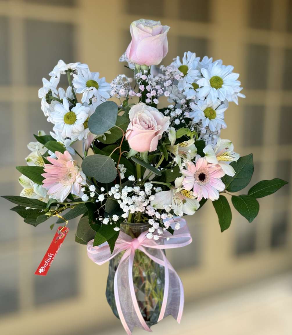 Delight your recipient with Orchids Little Secret Boutique Brilliant pink roses surrounded