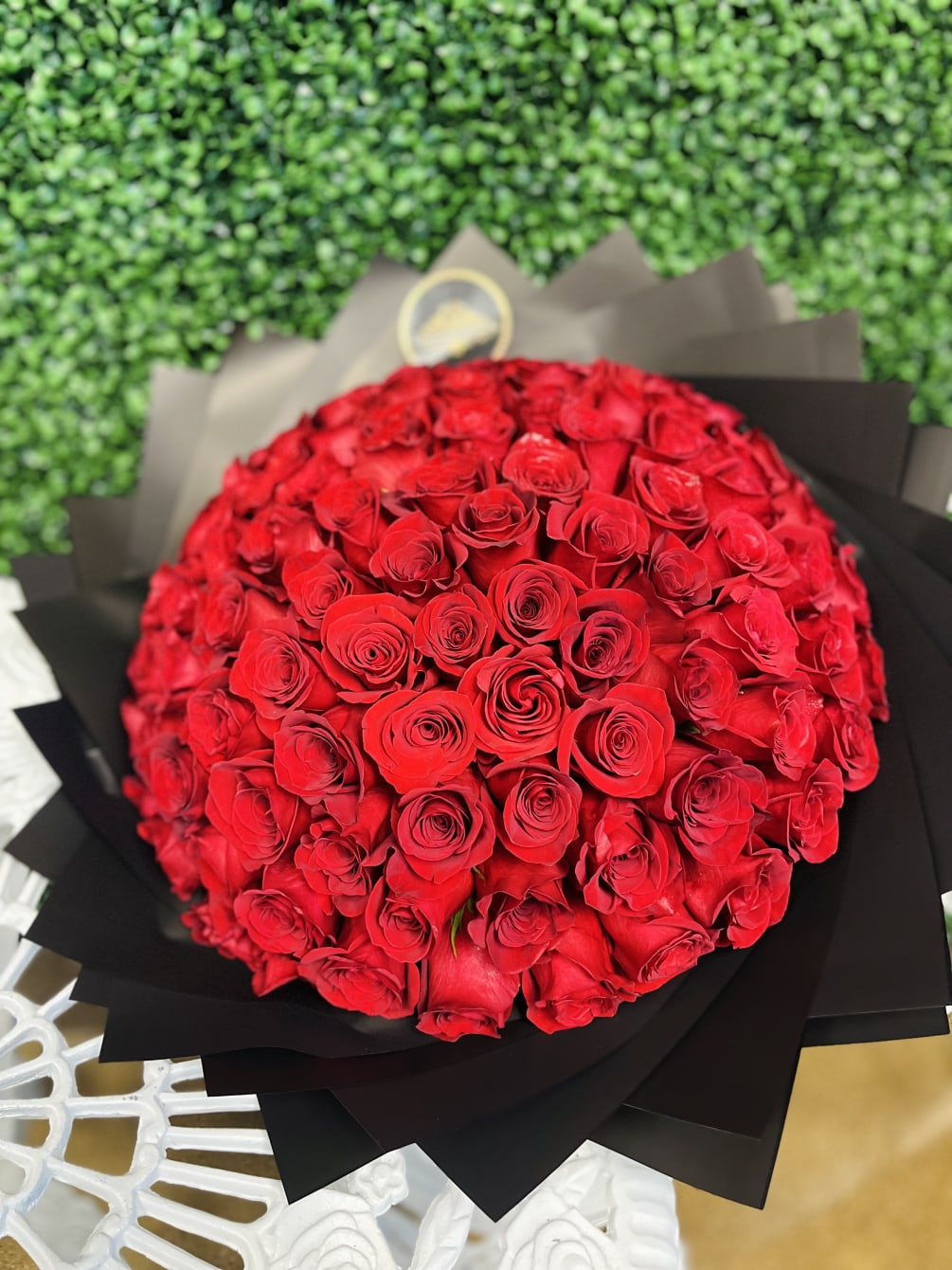 100 Long Stem Red Roses. Meticulously Wrapped with black paper with a