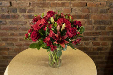 Red mixed flower bouquet in a clear glass vase