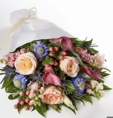Bouquet of peach roses, pink calla lilies, and blue thistle flowers