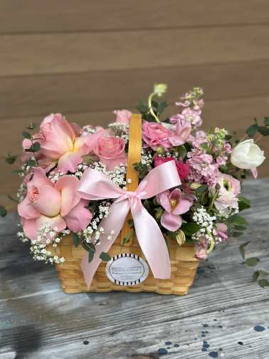 Pink floral basket with roses and a ribbon bow