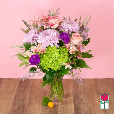 Bouquet of pink and purple flowers in a clear glass vase