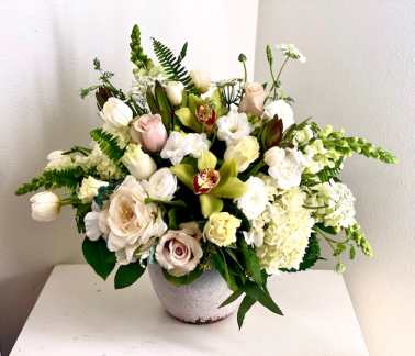 Mixed white and blush floral arrangement in a gray vase