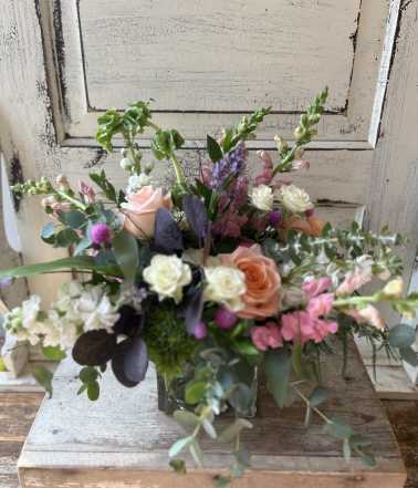 Mixed bouquet in a glass vase with pink, peach, and white flowers
