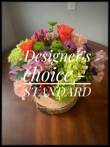 Mixed bouquet with roses, chrysanthemums, and hydrangeas on a wood slice base