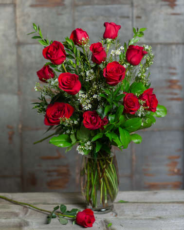 Red roses arranged in a clear glass vase