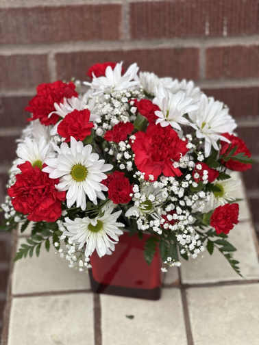 Red carnations and white daisies in a red container