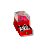 Red rose in a clear box above a drawer of chocolates