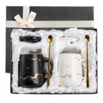 Gift box with two marble-pattern mugs and gold spoons
