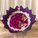Magenta rose bouquet with gold butterfly decorations and purple wrapping