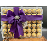 Box of Ferrero Rocher chocolates tied with a purple ribbon and bow