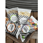 Assorted bags of gourmet popcorn in a wooden tray