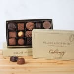 Box of assorted chocolates with two pieces outside the tray