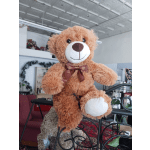 Brown teddy bear with a ribbon bow in a shop interior
