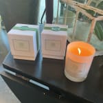 Two boxed gifts and a lit candle on a dark table