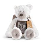 White teddy bear holding a framed photo and orange tag
