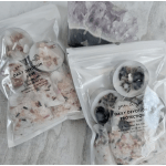Two packaged candle sets with floral petals and crystal pieces