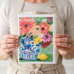 Person holding a floral congratulations card with a painted vase and flowers