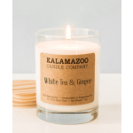 Lit white candle in a clear glass jar with a kraft label