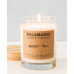 Lit candle in a clear glass jar with a kraft label