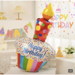 Birthday cake-shaped foil balloon with colorful polka dots and a candle topper